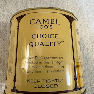 May include: Vintage Camel 100's cigarette tin. The tin is a light yellow color with dark brown decorative accents. The text on the tin reads "CAMEL 100'S CHOICE QUALITY" and "KEEP TIGHTLY CLOSED".