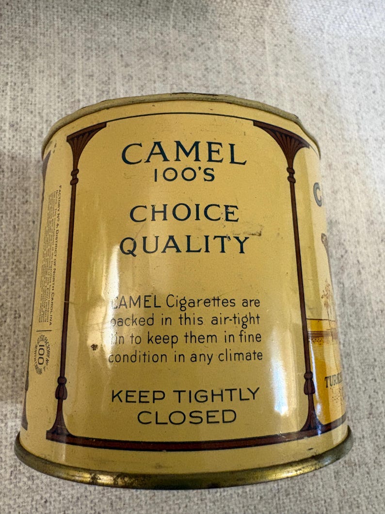 May include: Vintage Camel 100's cigarette tin. The tin is a light yellow color with dark brown decorative accents. The text on the tin reads "CAMEL 100'S CHOICE QUALITY" and "KEEP TIGHTLY CLOSED".