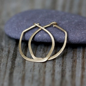 Op de afbeelding: Een paar gouden creolen met een licht ovale vorm. De oorbellen zijn simpel en elegant.