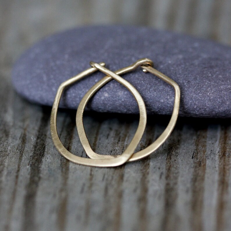 Op de afbeelding: Een paar gouden creolen met een licht ovale vorm. De oorbellen zijn simpel en elegant.