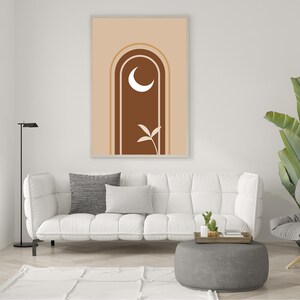 Op de afbeelding: Een digitale kunstprint met een bruine boog met een halve maan en een gestileerd bladontwerp. De achtergrond is licht beige van kleur.