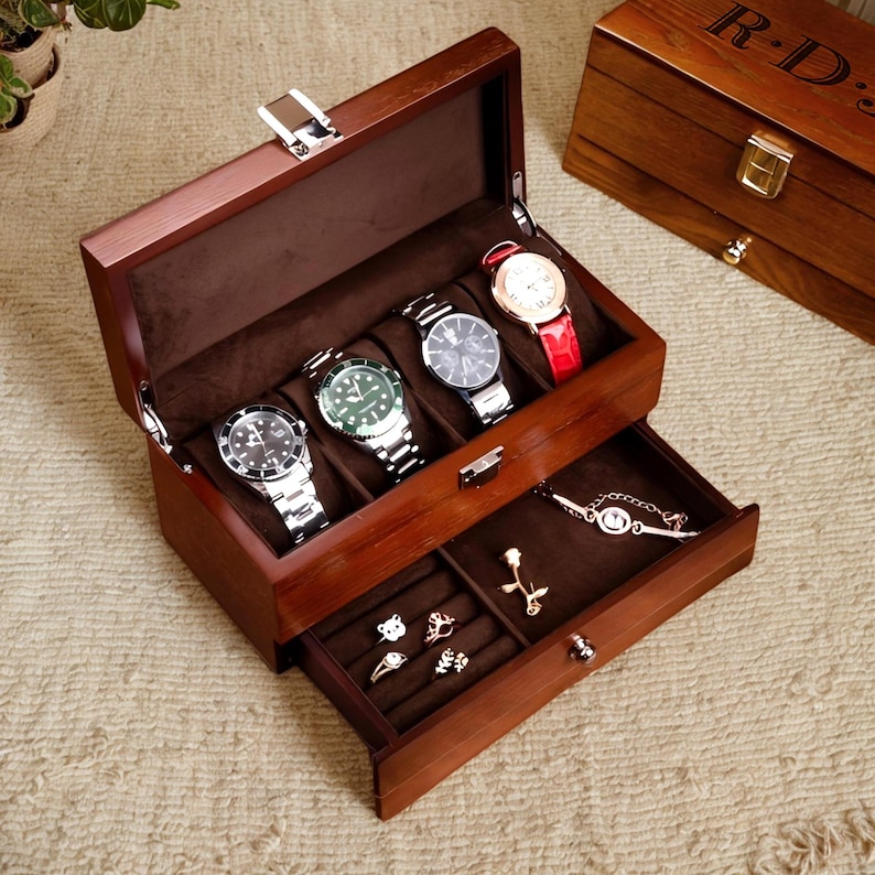 May include: A wooden watch box with a hinged lid and a drawer. The box has five slots for watches and the drawer has compartments for jewelry. The box is made of dark wood and has a polished finish.