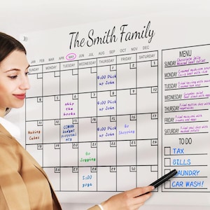 May include: A white dry-erase board with a monthly calendar and a to-do list. The calendar is labelled "The Smith Family" and has handwritten notes for each day. The to-do list includes items such as "TAX", "BILLS", "LAUNDRY", and "CAR WASH!"