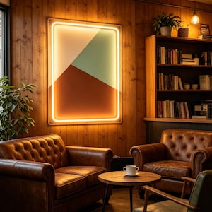Op de afbeelding: Een rechthoekige wandlamp met een geometrisch ontwerp, bestaande uit een witte bovenste driehoek en een donkerbruine onderste driehoek, omlijst door een doorlopende oplichtende oranje neonrand, gemonteerd op een verticale houten wand.