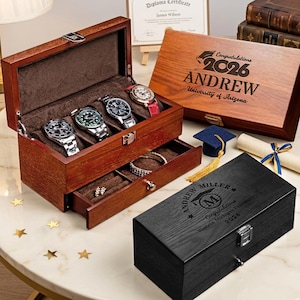 Könnte beinhalten: Eine Holz-Uhrenbox mit vier Uhren, eine Schublade mit Schmuck und zwei gravierte Holzkisten. Eine Kiste ist mit "Herzlichen Glückwunsch 2026 ANDREW University of Arizona" graviert. Die andere Kiste ist mit "ANDREW MILLER Herzlichen Glückwunsch Westein Michigan University 2026" graviert.