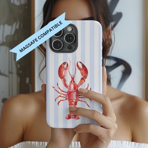 May include: A white and light blue striped phone case featuring a watercolor illustration of a red lobster. The phone case is labeled "MAGSAFE COMPATIBLE".