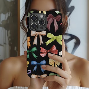 May include: A black phone case with a watercolor design of colorful bows. The case has a camera lens cutout and a black background.