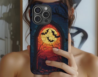 May include: A smartphone case featuring a Halloween-themed design. The case displays a vibrant illustration of a full moon, bats, and a gothic archway with a dark, cracked background. The color palette includes shades of orange, yellow, and blue.
