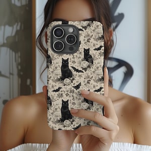 May include: A phone case featuring a repeating pattern of black cats, bats, and floral elements in a sepia tone. The case has a glossy finish and a camera cutout.