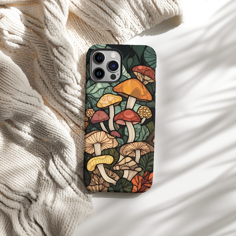 May include: A black phone case with a colorful illustration of mushrooms on a dark green background.