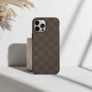 May include: A brown checkered phone case for an iPhone with a camera bump.