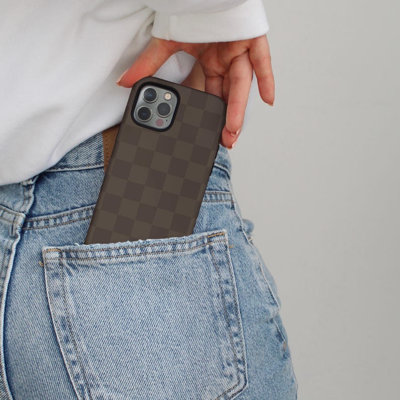 May include: A brown and black checkered phone case in a back pocket of blue jeans.