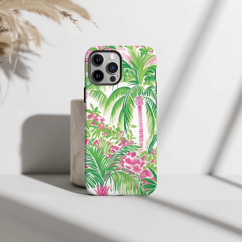 May include: White phone case with a tropical print featuring green palm trees and pink flowers.