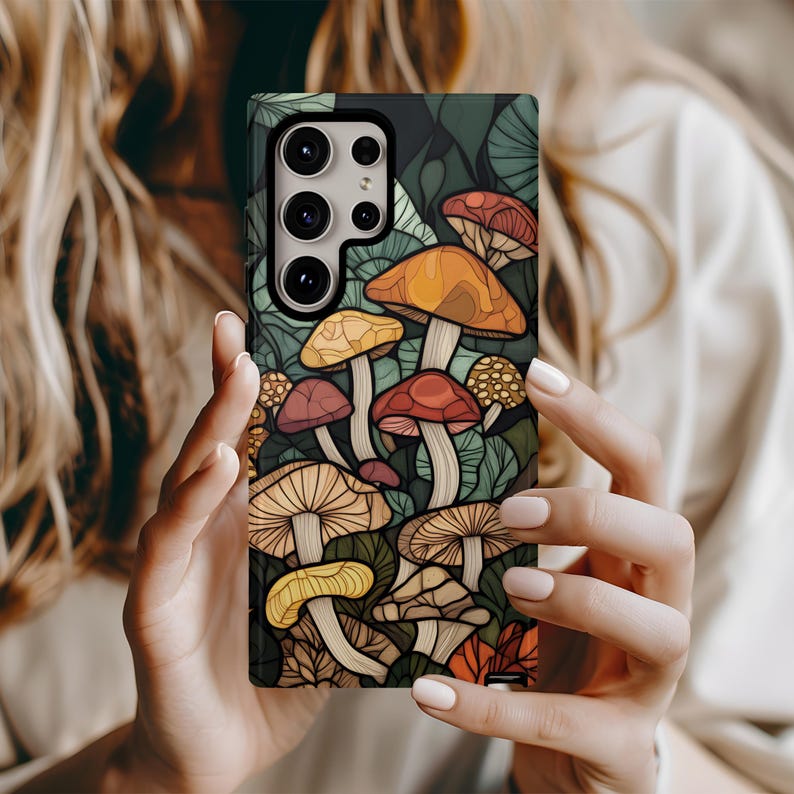 May include: A phone case with a colorful illustration of mushrooms on a dark green background. The case has a cutout for the phone's camera.