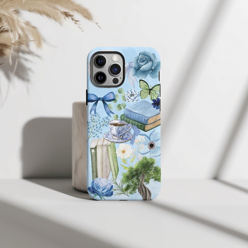 May include: A blue phone case with a watercolor design featuring books, flowers, a teacup, and a butterfly.