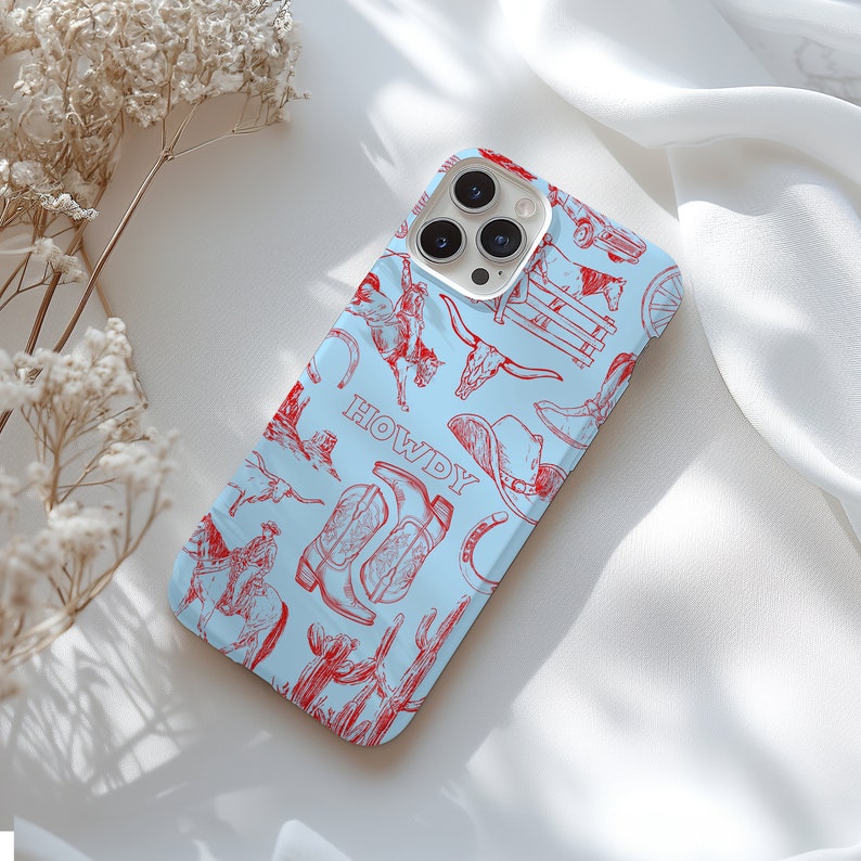 K&ouml;nnte beinhalten: Eine hellblaue iPhone-H&uuml;lle mit einem rot-wei&szlig;en Western-Design. Die H&uuml;lle zeigt verschiedene Bilder, darunter Cowboystiefel, Hufeisen und einen Cowboyhut. Der Text "HOWDY" ist auf der H&uuml;lle aufgedruckt.