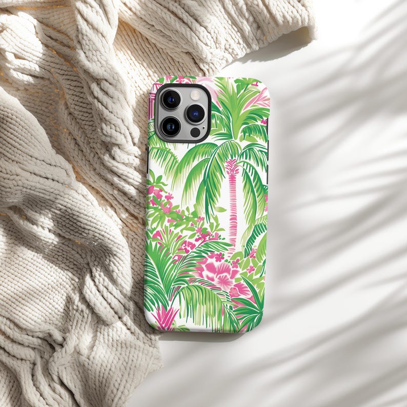 May include: A white phone case with a tropical print featuring green palm trees and pink flowers.