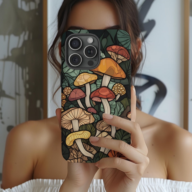 May include: A phone case with a colorful illustration of mushrooms on a dark green background. The case has a cutout for the camera lens.