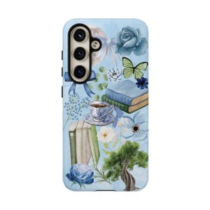 May include: A blue and white phone case with a floral design. The design includes a butterfly, a teacup, books, and a tree. The case has a cutout for a camera lens.