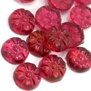 May include: A collection of small, red, glass flower-shaped buttons. The buttons have a raised, detailed flower design.