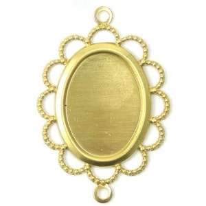 May include: Gold-toned metal pendant with an oval-shaped bezel and a decorative scalloped edge. The pendant has a loop at the top for hanging and a loop at the bottom for attaching a chain.