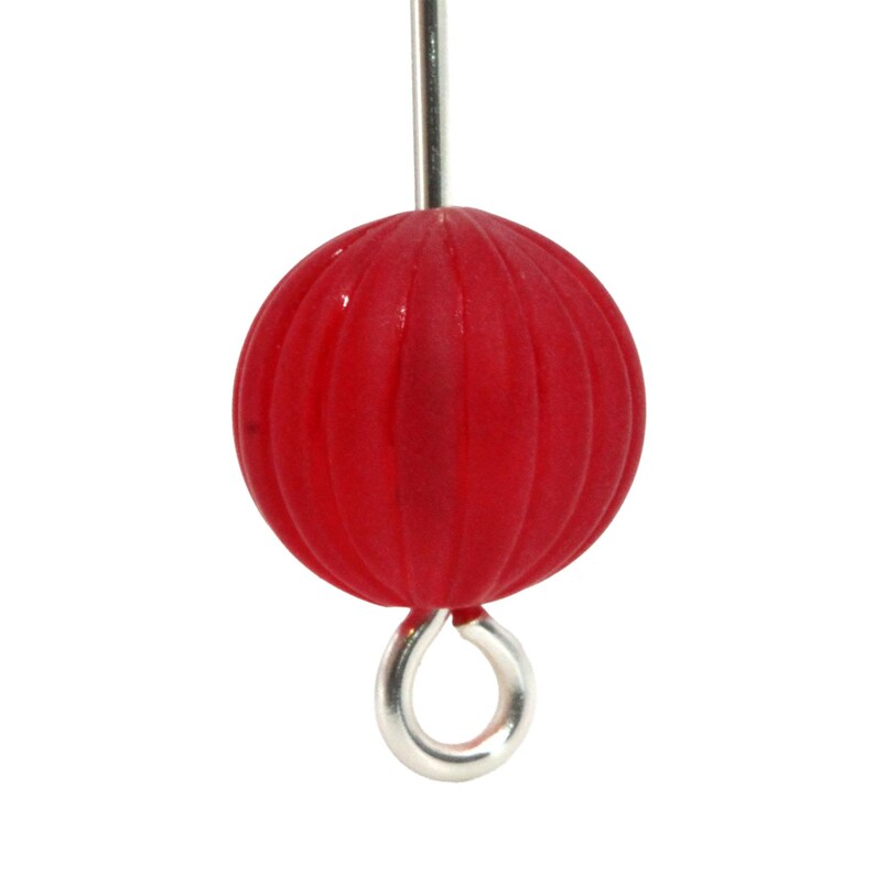 May include: A close-up of a red, round bead with vertical grooves. The bead is attached to a silver-colored metal eye pin. The bead is a vibrant red color and has a smooth, glossy finish. The eye pin is a simple loop.