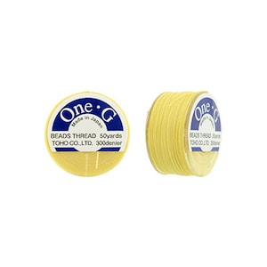 May include: A spool of yellow beading thread with a label that reads "One-G Made in Japan Beads Thread 50yards TOHO CO.,LTD. 300denier"