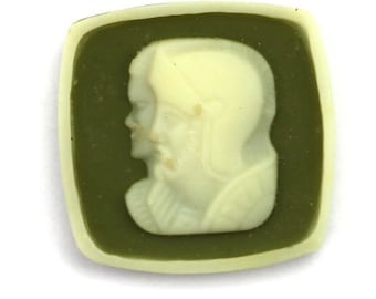 May include: A green and white cameo featuring a profile of a person wearing a helmet.