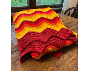 Manta de ganchillo vintage hecha a mano con estampado de espiga en rojo, naranja y amarillo.