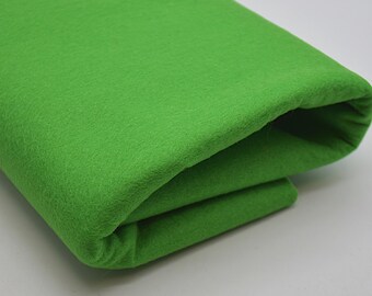 May include: A bright green felt fabric folded in half. The fabric is soft and smooth, and it is perfect for crafting projects.