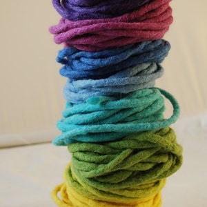 May include: A stack of colourful yarn in rainbow order, starting with purple and ending with red.