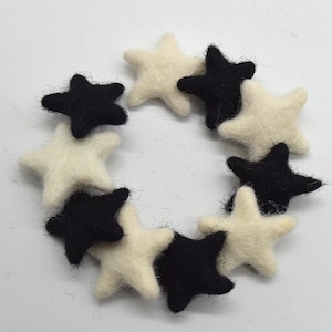 Könnte beinhalten: Ein Satz Filzsterne in Schwarz und Weiß. Die Sterne sind in einem Kreis angeordnet.