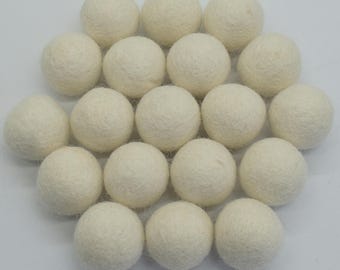 May include: A collection of 20 off-white felt balls. The balls are arranged in a circle, with the largest ball in the center.