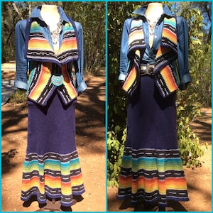 May include: A denim shirt and a navy blue knit skirt and vest set. The vest and skirt feature a colorful striped pattern in shades of orange, yellow, green, and blue. The vest has a turquoise button closure. The skirt is floor length.