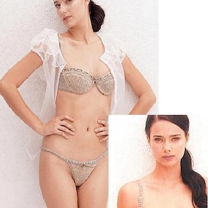 May include: A beige crochet lingerie set with a bra and matching panty. The bra has a scalloped edge and the panty has a delicate lace trim.