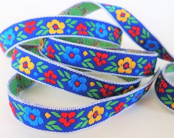 MORAVIAN DAISIES Jacquard trim. Red, yellow, green, blue on blue. White edges. Sold by the yard. 5/8 inch wide. 799-B Bavarian, Scandinavian