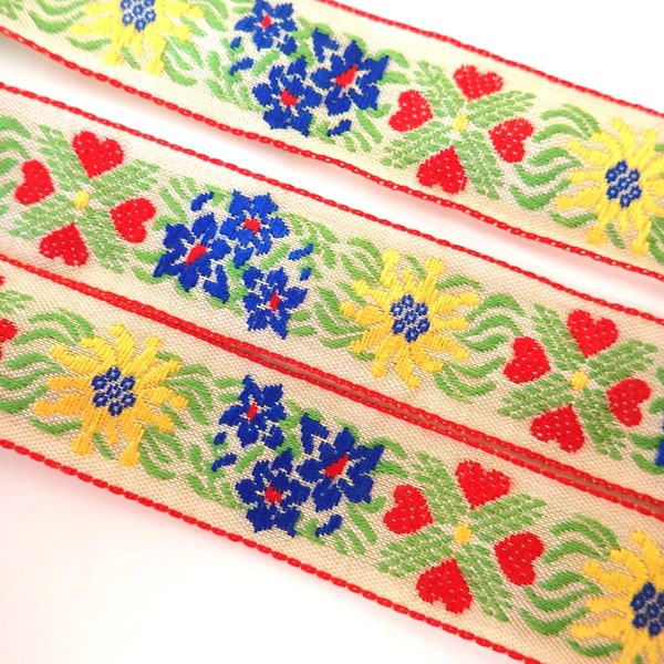 EDELWEISS & HEARTS Jacquard trim in yellow, blue, red, green on ecru off white. Sold by the yard. 1 inch wide. V2773-D Bavarian trim