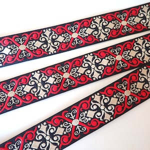 May include: Black, red and gold trim with a repeating ornate pattern. The trim is woven and has a slightly raised texture.