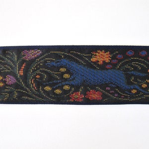 Medieval tapestry wide Jacquard trim with a brown stag and a blue wolf in a floral garden on a black background