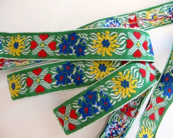 EDELWEISS & HEARTS Jacquard trim in yellow, white, blue, red on green. Sold by the yard. 1 inch wide. V2773-A Bavarian trim