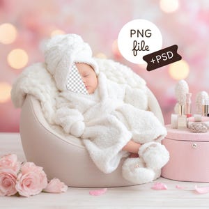 May include: A baby in a white fluffy robe, booties, and hood, resting in a light-coloured chair. A pink box with beauty products and a bouquet of pink roses are nearby. The background is soft and blurred with bokeh.