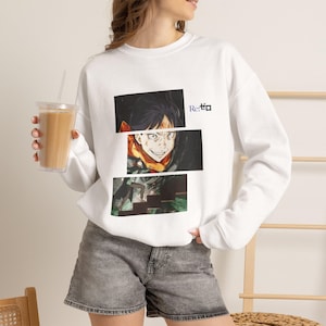 May include: A white long-sleeve sweatshirt featuring a graphic print of an anime character with an intense expression, divided into three horizontal panels. The text Re:ゼロ is printed in blue and black near the top right of the graphic design.