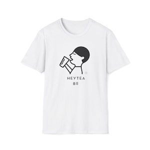 May include: White t-shirt with a black graphic of a person drinking from a cup. The text "HEYTEA" is below the graphic, with Chinese characters beneath it. The shirt has short sleeves and a crew neck.