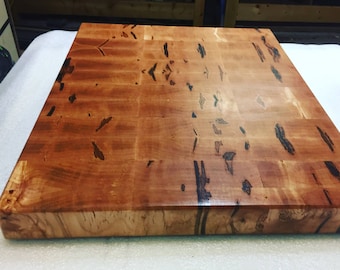 Puede incluir: Una tabla de cortar de madera grande, rectangular, hecha de madera de arce con un acabado natural. La tabla tiene un patrón de veta único y es perfecta para preparar alimentos.