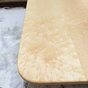 May include: Close-up of a light wood surface with a unique, natural pattern of small, light brown spots. The surface is smooth and appears to be made of wood.