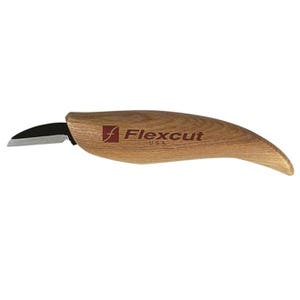 May include: A wood carving knife with a curved blade and a wooden handle. The handle is light brown with the brand name "Flexcut USA" printed in red and black. The blade is black and angled.