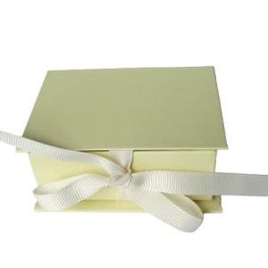 May include: A pale yellow gift box with a white satin ribbon tied in a bow.