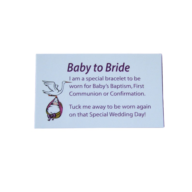 May include: A light blue card with the text "Baby to Bride" in purple lettering. The card features a cartoon illustration of a stork carrying a baby in a basket. The text reads: "I am a special bracelet to be worn for Baby's Baptism, First Communion or Confirmation. Tuck me away to be worn again on that Special Wedding Day!"