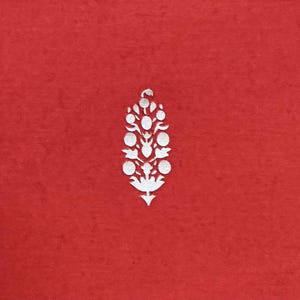 May include: A red background with a white floral design. The design is a stylized, symmetrical arrangement of circles and leaf shapes, resembling a flower or a decorative element. The design is centered on the red background.