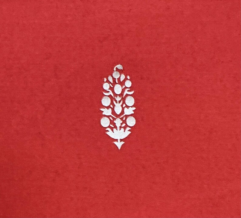 May include: A red background with a white floral design. The design is a stylized, symmetrical arrangement of circles and leaf shapes, resembling a flower or a decorative element. The design is centered on the red background.